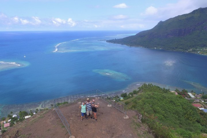 a group of people on a rocky shore next to a body of water