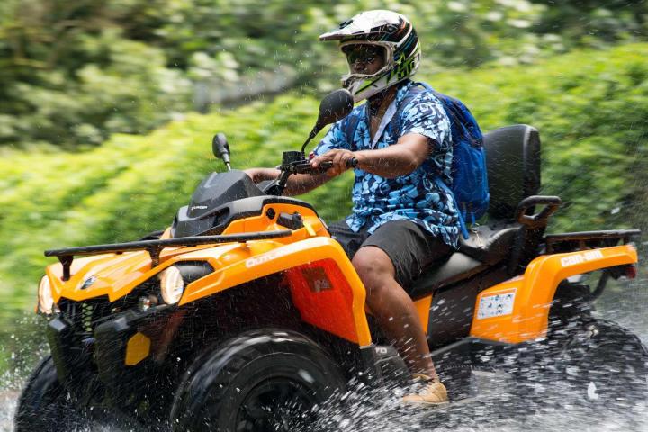 Man riding ATV through stream on Tahiti