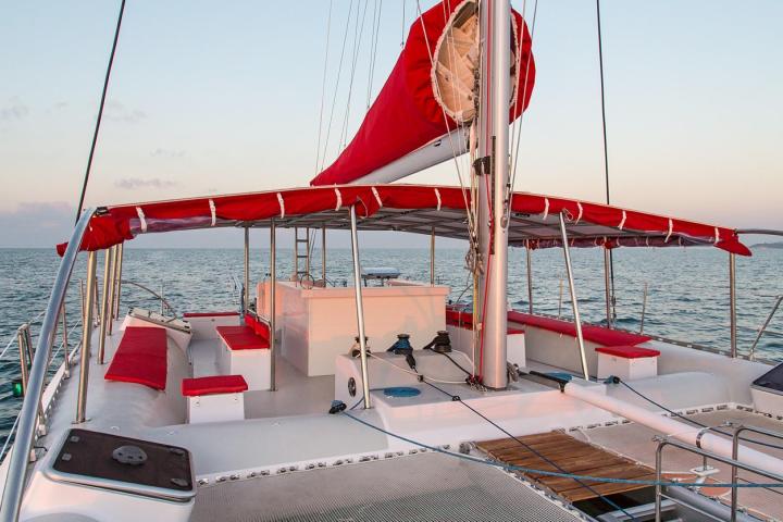 a red and white boat sitting next to a body of water